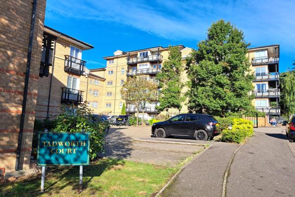 A mid-rise block of flats with yellow brick walls and balconies